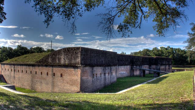 A masonry fort stands in a terraced field of grass. — Gulf Islands National Seashore, NPS