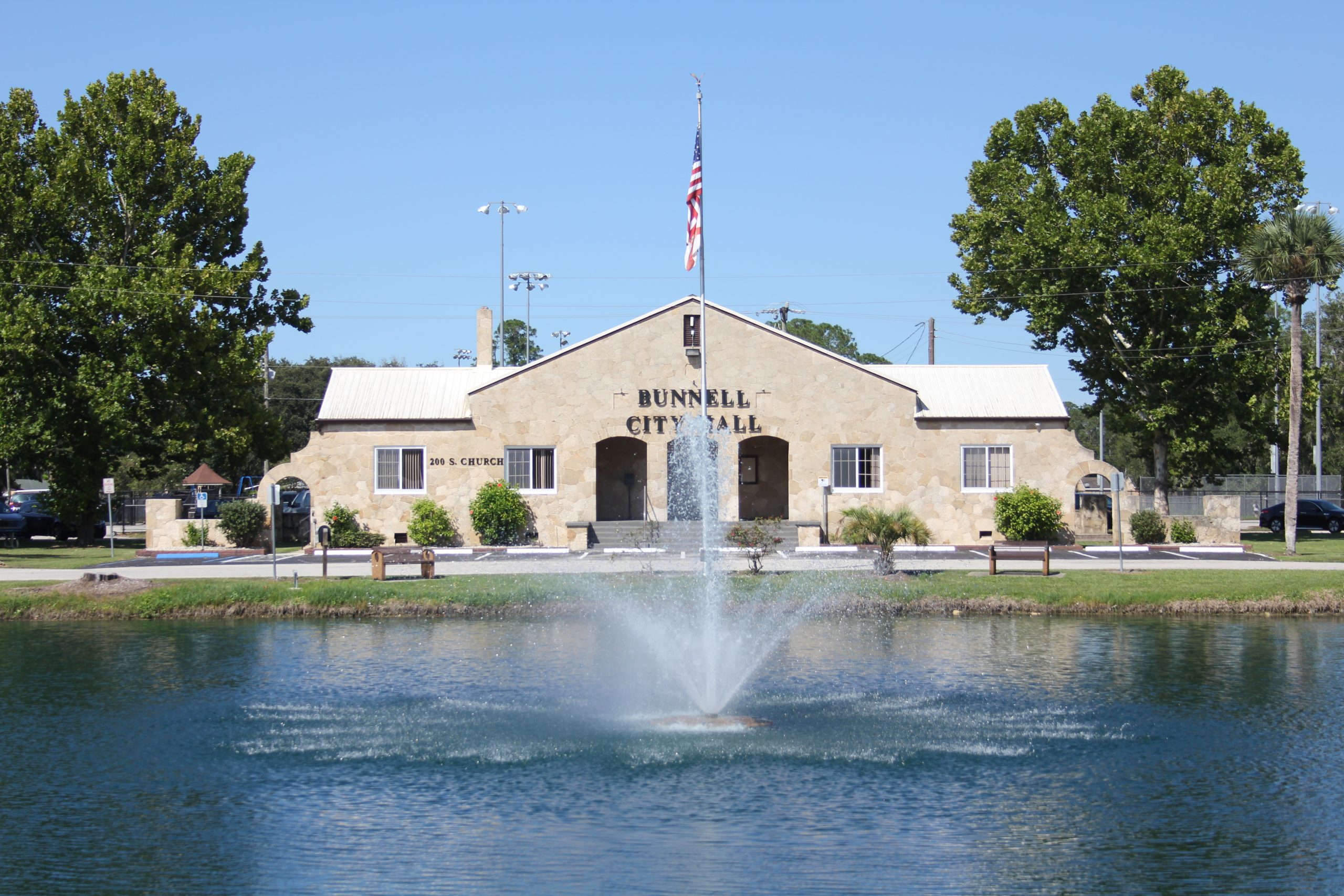 Photograph of the Bunnell Coquina City Hall - Full Front View with Lake Lucille & Fountain