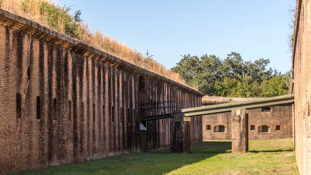 Masonry walls raise on both sides, a drawbridge connects the two. — Gulf Islands National Seashore, NPS